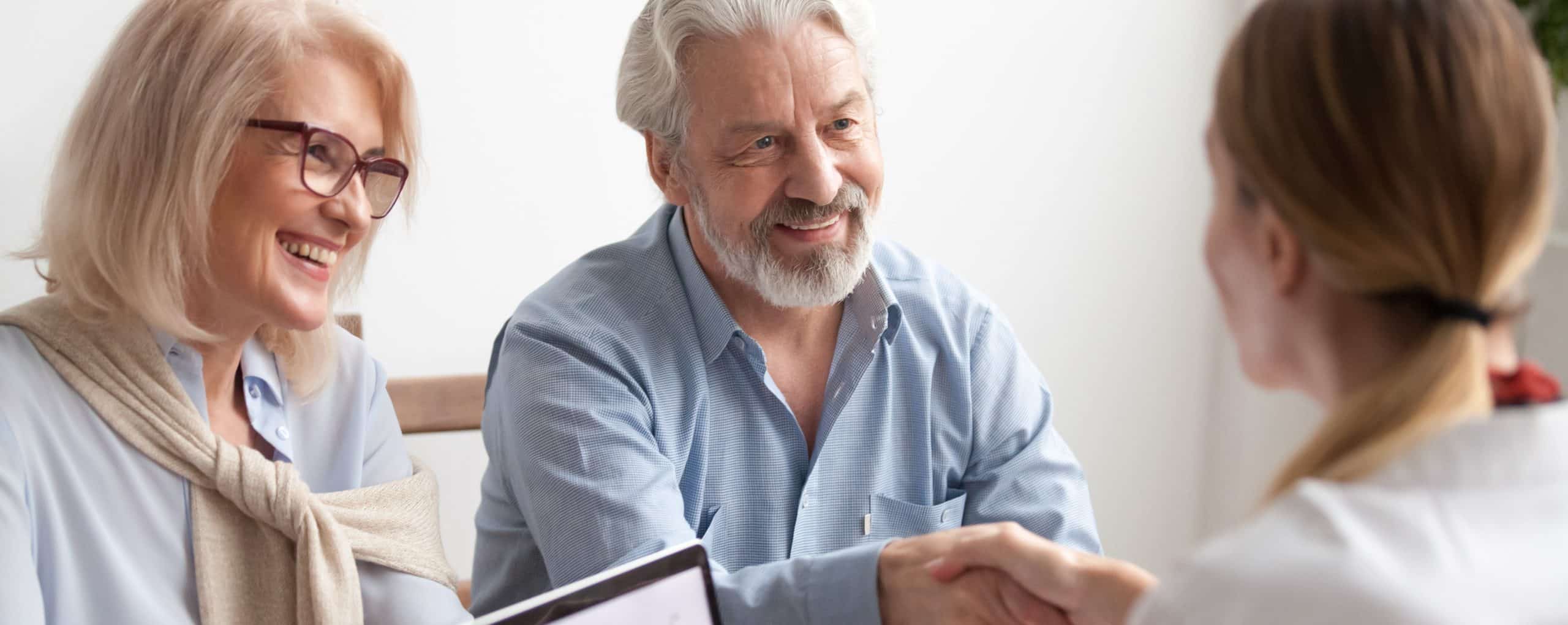 Senior couple make deal shaking hands with real estate agent